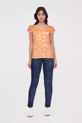Remera de manga corta color rosa con estampado de flores naranjas, cuello redondo y corte holgado.
