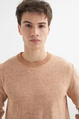 Sweater de punto color naranja claro jaspeado, con cuello redondo y mangas largas.