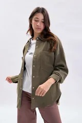 Sobrecamisa de pana color verde, con cuello clásico, cierre frontal con botones metálicos y dos bolsillos delanteros con solapa.