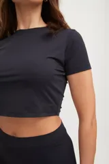 Remera corta negra ajustada al cuerpo, confeccionada en tejido suave con protección UV50+.