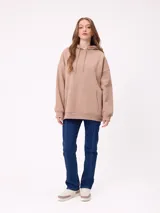 Canguro negro de corte holgado con capucha y cordones ajustables. Presenta un bolsillo frontal tipo canguro y un pequeño logo bordado en el pecho.