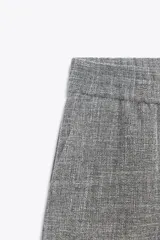 Pantalón de tiro alto color gris jaspeado, con cintura elástica y pernera ancha.