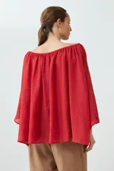 Blusa roja con escote bardot y mangas largas amplias.
