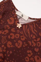 Vestido largo hasta el tobillo color marrón con estampado animal, breteles finos y escote en V profundo con detalle de flor.