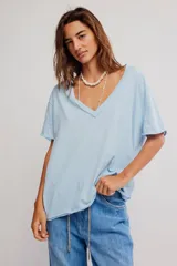 Remera de algodón celeste, de corte oversize con escote en V amplio y mangas cortas caídas.