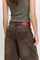 Jeans wide leg tiro medio de color marrón con efecto acid wash y costuras pespunteadas.