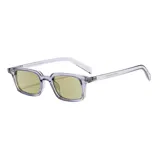 Lentes con armazón rectangular de acetato transparente en tono verdoso y cristales amarillos.