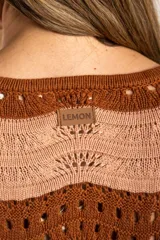Sweater de tejido de punto con diseño de rayas horizontales onduladas en tonos marrón y beige. Presenta cuello redondo, mangas largas y corte oversize.