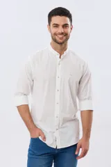 Camisa de lino y algodón color blanco, con cuello mao, manga larga y cierre frontal de botones. Presenta un pequeño logo bordado en el pecho.