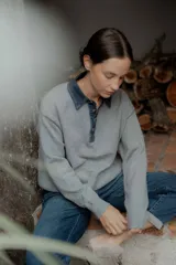 Buzo de punto gris con cuello camisero de denim y cierre frontal parcial con botones metálicos. Presenta mangas largas y un diseño de calce holgado.