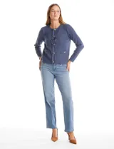 Cardigan de punto color fucsia, con escote a la base, cierre frontal con botones metálicos dorados y terminaciones desflecadas. Presenta bolsillos simulados en la parte delantera y mangas largas.