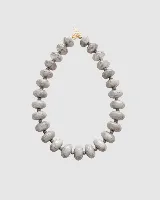 Collar de cuentas redondas y aplanadas con efecto marmolado en tonos grisáceos, con cierre metálico dorado.
