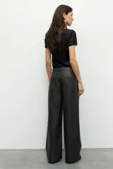 Pantalón ancho de símil cuero color negro, con grandes bolsillos laterales y traseros.