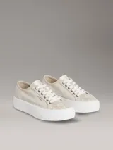 Zapatillas de plataforma Calvin Klein con diseño de jacquard monograma en tonos beige, suela blanca gruesa y cordones blancos.