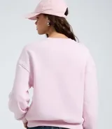Buzo de algodón con felpa, color rosado, con cuello redondo, mangas largas y puños y bajo en rib. Presenta un estampado localizado en el pecho.