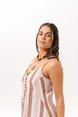 Vestido largo a rayas verticales en tonos rosados, marrones y blancos, con tirantes finos y escote en V.