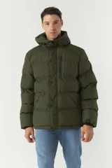 Campera puffer negra de nylon con cuello alto y capucha ajustable. Tiene bolsillos laterales y frontales con cierre.