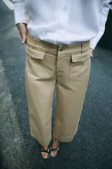 Pantalón culotte de tiro alto en color verde militar. Presenta bolsillos frontales de plastrón con solapa, cierre frontal con cremallera y botón, y diseño de pierna ancha con dobladillo marcado.