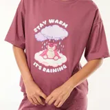 Conjunto de pijama de dos piezas color rosa con estampado de nubes. Incluye una remera de mangas cortas con un estampado de Lotso, el oso de Toy Story, sobre una nube con la frase "Stay Warm It's Raining", y un pantalón largo con puños y estampado de nubes.