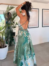 Vestido largo verde con diseño estampado tipo tie-dye y detalles dorados, de corte fluido, un solo hombro y diseño amplio.