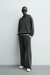 Sudadera tipo hoodie de corte relajado, confeccionada en tejido fluido con efecto lavado. Presenta cuello con capucha, mangas largas y terminaciones en rib.