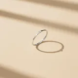 Anillo de oro blanco 18k con un brillante central de 0.05cts. Diseño fino y minimalista, ideal para combinar con otras alianzas.
