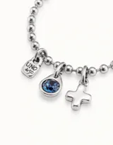 Dije charm con forma de cruz minimalista, bañado en plata. Compatible con pulseras y collares. Diseño unisex.