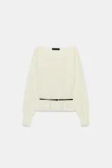 Jersey de punto negro con cuello barco y mangas largas amplias. Presenta un diseño ajustado en la cintura con un cinturón fino integrado que incluye una hebilla metálica dorada.