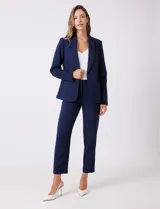 Blazer sastrero entallado color beige, con cuello de solapa, cierre frontal con un botón a tono y hombreras estructuradas. Presenta bolsillos laterales con solapa y forro interno.