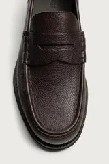 Mocasín de vestir para hombre confeccionado en piel con acabado abatanado, de color marrón. Cuenta con detalle de antifaz en el empeine, horma redonda, plantilla interior de piel y suela a contraste con ligero tacón.