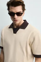 Polo de punto azul marino, de corte regular fit, con cuello solapa, abertura frontal en V y mangas cortas.