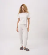Pijama largo Lov de dos piezas confeccionado en tejido peach touch color blanco con delicado estampado floral y texto frontal, compuesto por remera de manga corta con cuello redondo y pantalón jogger con cintura elastizada.