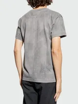 Remera de algodón con cuello redondo y mangas cortas, presenta un estampado con efecto craquelado en tonos rosados.