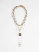 Collar triple con cadenas de eslabones en tonos plateados y dorados, adornado con pequeñas cuentas. Incluye un dije ovalado con incrustaciones de pedrería y un dije en forma de cuerno.