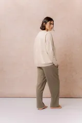 Buzo de calce relajado color beige, con cuello redondo, manga larga y recortes curvos decorativos con costuras a la vista en el frente. Terminaciones en puños y cintura.