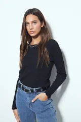 Remera de manga larga con ajuste al cuerpo, confeccionada en tejido acanalado con terminaciones onduladas en los puños y cuello redondo.