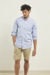 Camisa celeste de algodón con cuello abotonado, manga larga con puños abotonados y bolsillo en el pecho. Corte clásico.