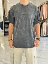Remera de corte oversize color azul, con efecto gastado y pequeño texto bordado en el pecho.