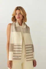 Bufanda de lana natural con diseño patchwork en tonos crema y beige, presentando bloques lisos y bloques con rayas horizontales.