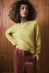 Pantalón de tiro medio confeccionado en 100% piel, con diseño de pierna ancha, cintura con trabillas, bolsillos laterales y cierre frontal con cremallera, botón y ganchos metálicos.