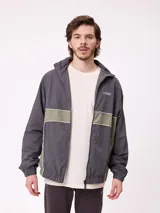 Rompevientos Rusty con cierre frontal, capucha y diseño de bloques de color en gris y verde militar. Cuenta con puños elásticos y logo de la marca en el pecho.