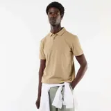 Remera polo color beige de manga corta, confeccionada en tejido texturizado tipo nido de abeja, con cuello camisero y cierre frontal de botones.