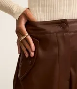 Pantalón recto de cuero sintético color marrón, con bolsillos cargo laterales y cierre frontal con botón y cremallera.