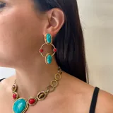 Aretes colgantes de bronce con diseño geométrico y engarce de piedras naturales. Presentan dos óvalos grandes de piedra turquesa, dos piedras redondas rojas y dos piedras redondas de ojo de tigre, unidos por aros de bronce.