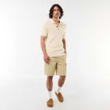 Remera tipo polo de manga corta confeccionada en tejido de punto con textura acanalada, color beige, con cuello camisero y cartera de tres botones carey.
