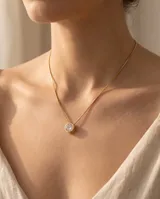 Collar de acero con baño dorado, de cadena fina estilo veneciano, con un dije colgante redondo tipo punto de luz engastado con circonía.
