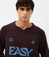 Suéter de punto en jacquard color bordó con diseño de cuello polo y cierre frontal parcial. Presenta estampado frontal con la palabra 'EASY' y la frase 'plans being' en color celeste, además de un pequeño logo bordado. Posee mangas largas con puños acanalados y un corte holgado.