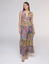Vestido largo sin mangas de gasa color rosa, con estampado tipo patchwork tropical que incluye piñas, flamencos y motivos botánicos. Cuenta con un pronunciado escote en V y cintura elastizada.