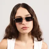 Lentes de sol con marco metálico dorado de forma rectangular y cristales oscuros con protección UV400.