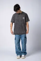 Remera de corte semi-oversize en color naranja con efecto de lavado tipo snow. Presenta un pequeño estampado gráfico en el pecho y cuello redondo.